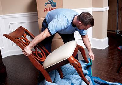 Mover unpacking a chair from moving supplies